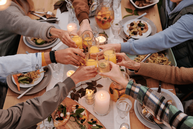 Friends sharing a  meal and toasting with juice glasses.