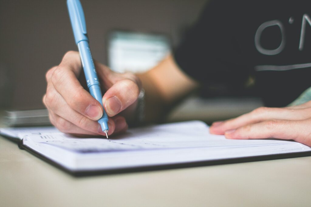 student writing with blue pen