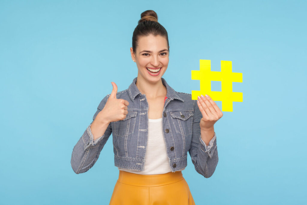 a woman holding up a hashtag sign